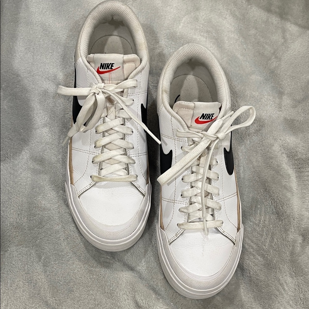 Nike White Low-Top Sneakers with Black Swoosh and Red Tongue Logo